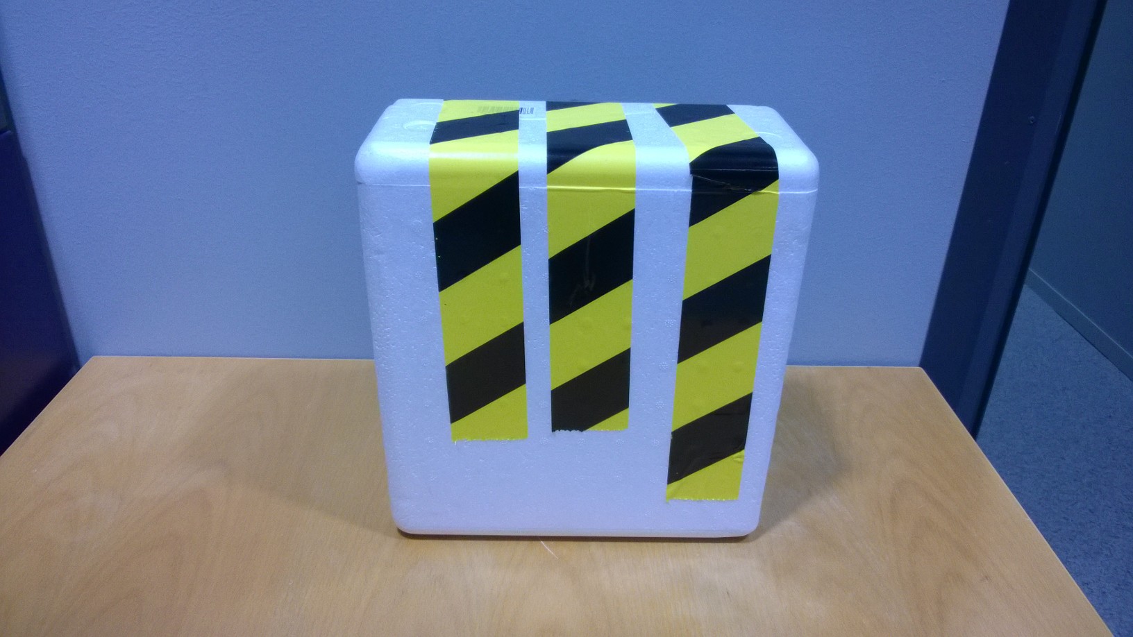 St&auml;ng f&ouml;rpackningen med gul-svartrandig tejp