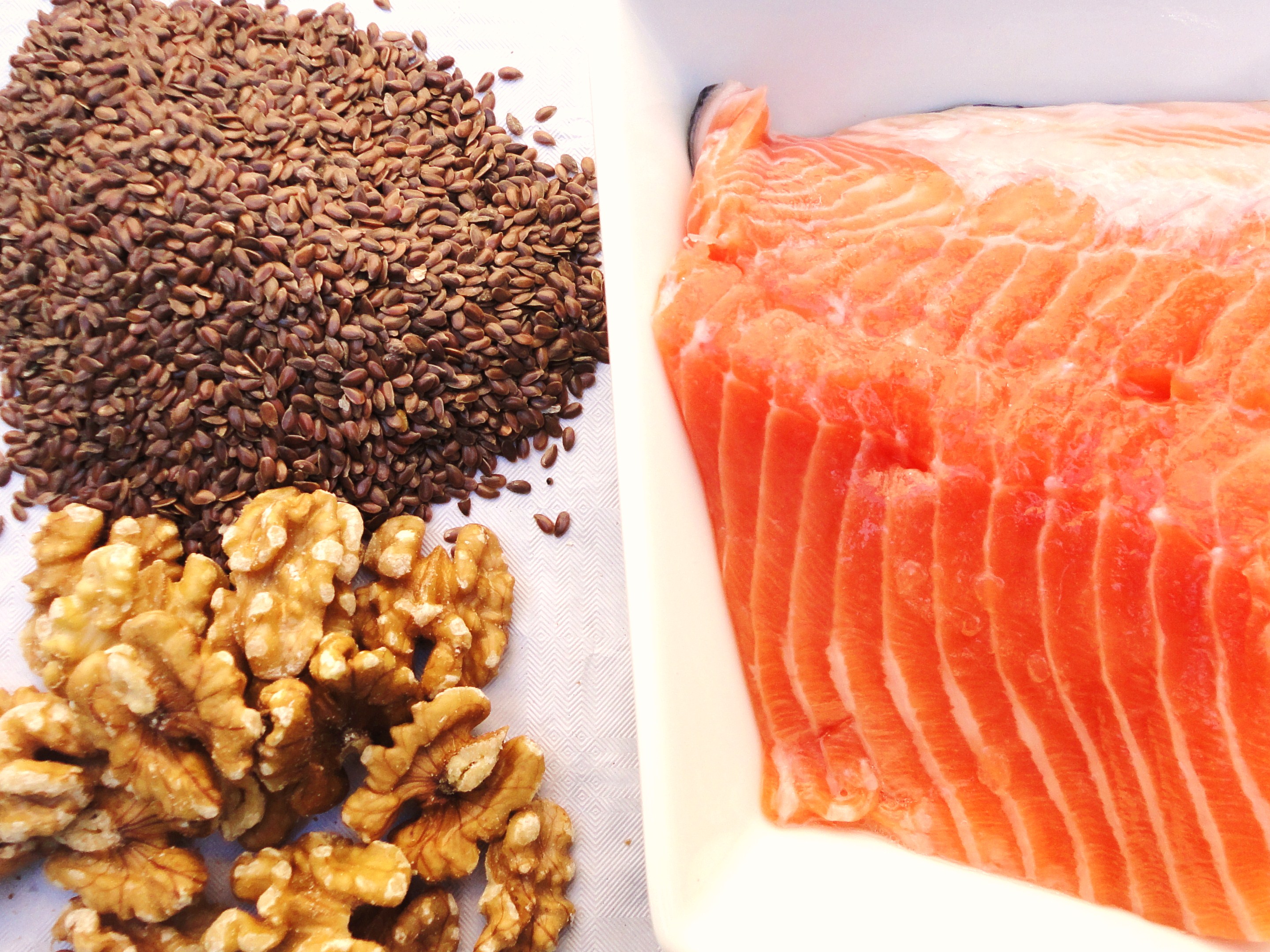 Kuvassa pellavansiemeni&auml;, saksanp&auml;hkin&ouml;it&auml; ja pala lohta