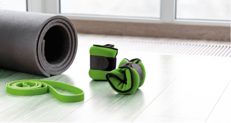 P&aring; bilden gymnastikutrustning s&aring;som gummiband, gymnastikmatta och vristvikter.