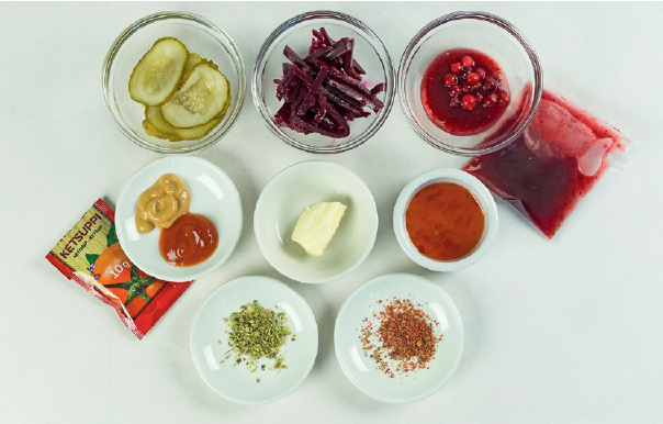 Kuvassa ruoan makulis&auml;kkeit&auml; kuten ketsuppia, sinappia, margariinia, mausteita, etikkapunajuurta, herkkukurkkuja ja puolukkasurvosta, joilla voi korvata suolan m&auml;&auml;r&auml;&auml; ja saada enemm&auml;n makua ruokaan.