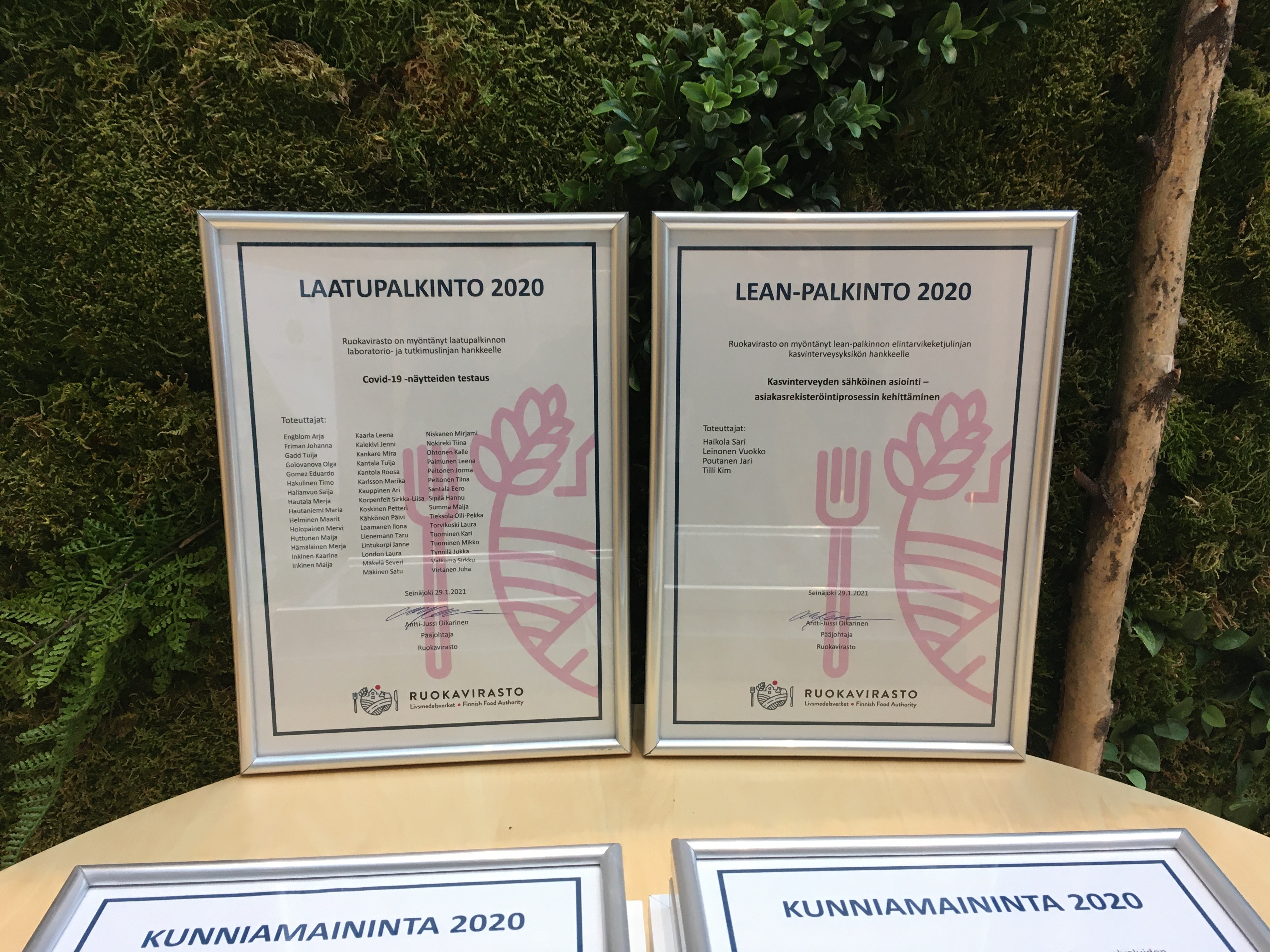 Kaksi kehystetty&auml; palkintopaperiarkkia.