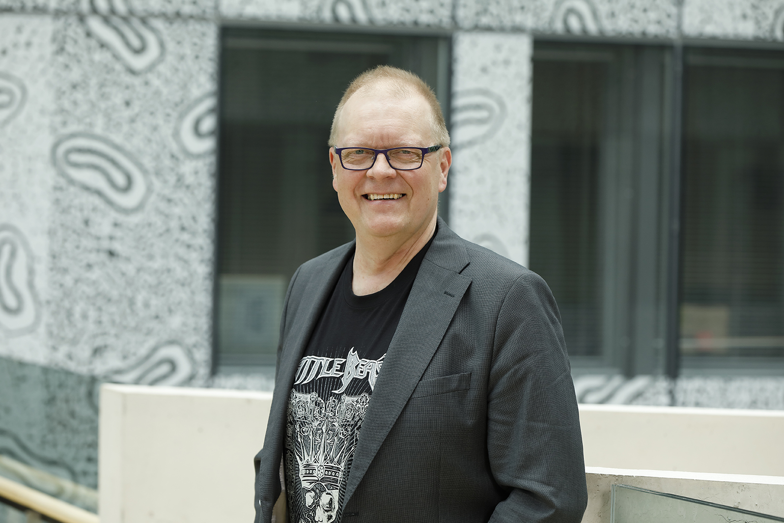 Matti Puolimatka seisoo rakennuksen ovien edess&auml;.